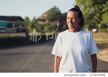 Smiling Mature Scandinavian Tourist Woman Walking Outdoors on Summer Holiday 137028998