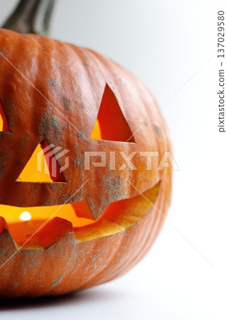 Sparkling carved pumpkin showing warm internal glow and playful expression. Close up of shimmering carved pumpkin with textured surface and cheerful internal illumination 137029580