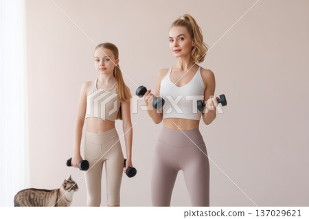 Women exercising together, Charming scene of women training and socializing at home, Two women in neutral activewear engaging in light workout with pet and cheerful conversation 137029621