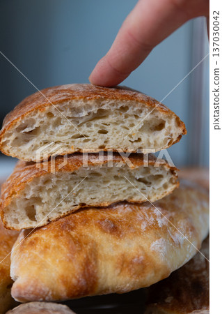 Soft Interior of Stacked Ciabatta Bread Loaves Touched by Finger Soft Interior of Stacked Ciabatta Bread Loaves Touched by Finger 137030042