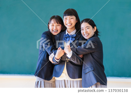 High school girls having fun with their friends in front of the blackboard High school girls having fun with their friends in front of the blackboard 137030138