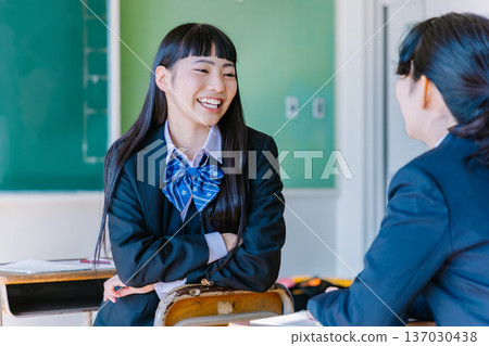 高中女生在教室裡和朋友愉快地聊天 137030438