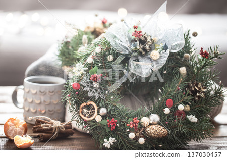 Christmas still life of trees and decorations, festive wreath on a background of knitted clothes and beautiful cups Christmas still life of trees and decorations, festive wreath on a background of knitted clothes and beautiful cups 137030457
