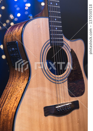 Close-up, acoustic guitar on a dark background with bokeh lights. Close-up, acoustic guitar on a dark background with bokeh lights. 137030518