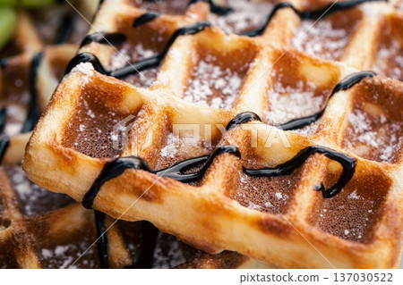 Close-up, appetizing Belgian waffles drizzled with chocolate. 137030522