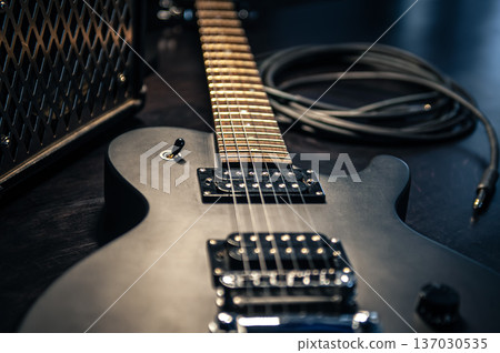Close-up, black electric guitar on a dark background. 137030535
