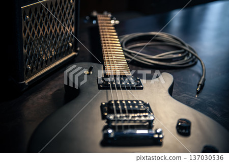 Close-up, black electric guitar on a dark background. 137030536