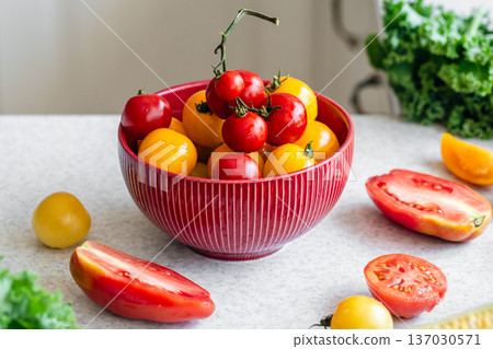 Close-up, a bowl of ripe red and yellow tomatoes on the kitchen table. 137030571