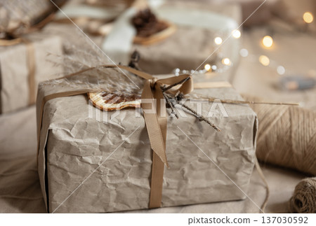 Christmas background with gift box wrapped in craft paper on blurred background. 137030592