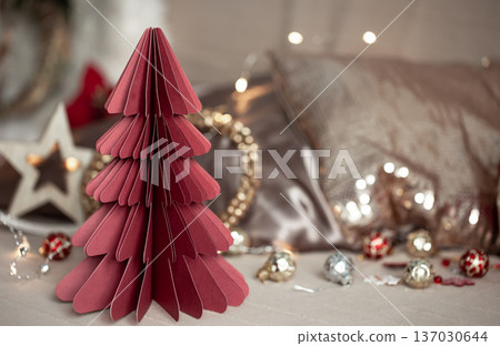 Close-up of a decorative cardboard Christmas tree on a blurred background. Close-up of a decorative cardboard Christmas tree on a blurred background. 137030644
