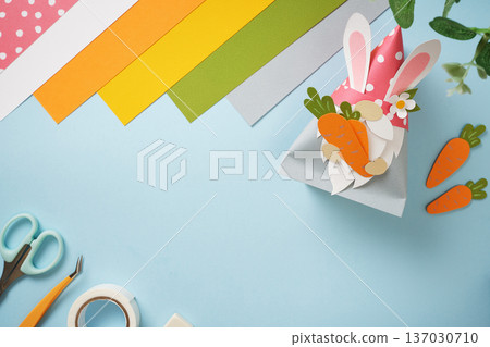 Paper crafts gnome with carrot. Items for paper art colored sheets, glue, scissors on a blue background. Copy space. Paper crafts gnome with carrot. Items for paper art colored sheets, glue, scissors on a blue background. Copy space. 137030710