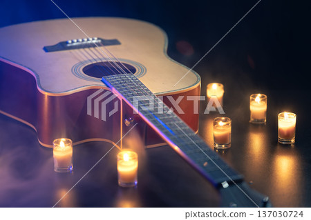 Acoustic guitar on a black background with candles. Acoustic guitar on a black background with candles. 137030724