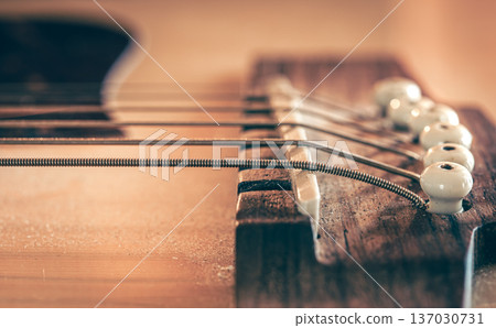 Acoustic guitar bridge and strings close up. 137030731