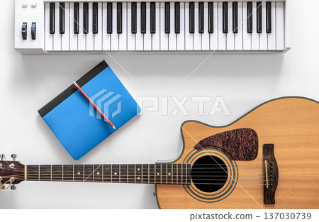 Acoustic guitar and musical keys on a white background, flat lay. 137030739