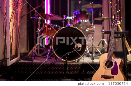 A room for musicians rehearsals with acoustic guitar and drum kit in the background. 137030754