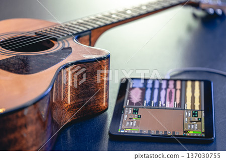 Acoustic guitar and tablet on the table, music recording concept. 137030755
