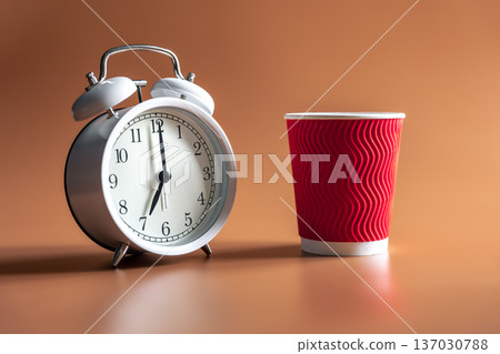 Alarm clock and paper disposable cup of coffee. Alarm clock and paper disposable cup of coffee. 137030788