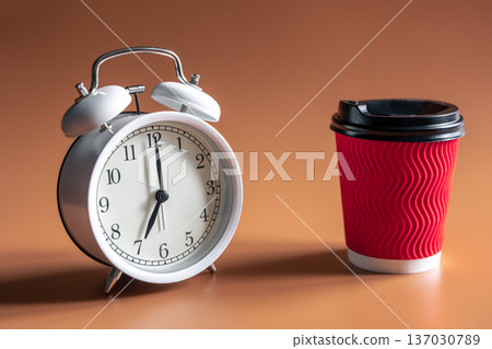 Alarm clock and paper disposable cup of coffee. 137030789