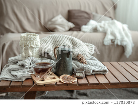 Autumn home composition with a cup of tea, a teapot and a knitted element. Autumn home composition with a cup of tea, a teapot and a knitted element. 137030878