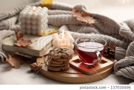 Autumn still life with a cup of tea, cookies and a knitted item. Autumn still life with a cup of tea, cookies and a knitted item. 137030896