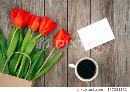 Bouquet of red tulips, a cup of coffee and a blank sheet, space for text. Bouquet of red tulips, a cup of coffee and a blank sheet, space for text. 137031182