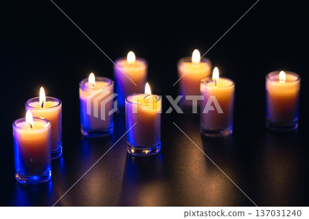 Burning candle on black background with backlight. Memorial Day. 137031240
