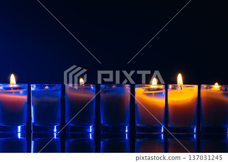 Burning candle on black background with backlight. Memorial Day. 137031245