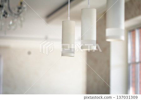 Chandelier in the interior of the room, lamps in white shades. 137031309