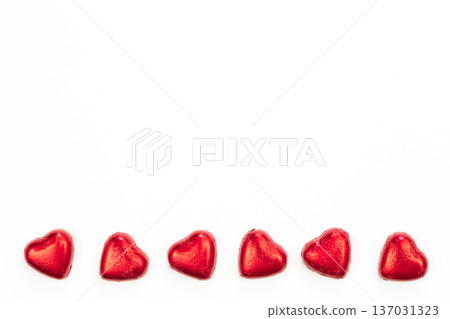 Chocolate sweets in the form of hearts on a white background, flat lay. Chocolate sweets in the form of hearts on a white background, flat lay. 137031323