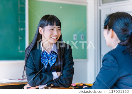 高中女生在教室裡和朋友愉快地聊天 137031563