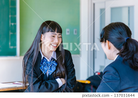 高中女生在教室裡和朋友愉快地聊天 137031644