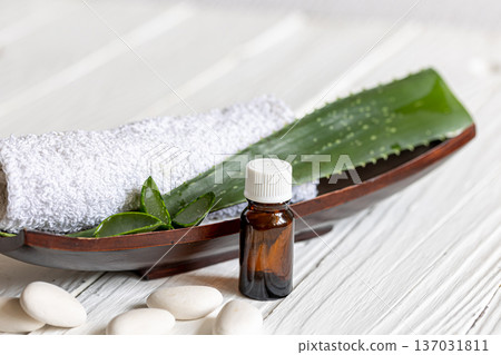 Spa composition with a jar of natural oil and aloe leaves with a towel. Spa composition with a jar of natural oil and aloe leaves with a towel. 137031811