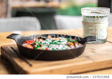 Close-up of traditional shakshuka in a frying pan. Close-up of traditional shakshuka in a frying pan. 137031908