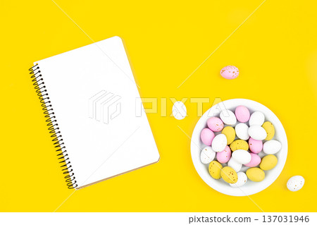 Colored Easter eggs and a blank notepad on a yellow background. Colored Easter eggs and a blank notepad on a yellow background. 137031946