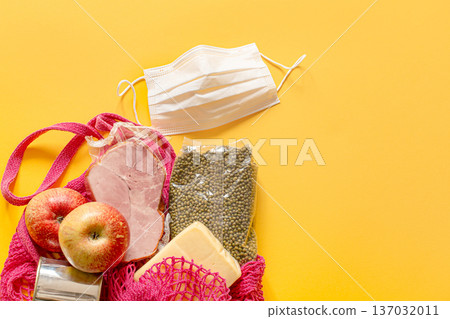 A shopping bag with basic food during quarantine and a protective mask. A shopping bag with basic food during quarantine and a protective mask. 137032011