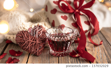 A composition for Valentine's Day with a red drink, a gift and decor details. 137032029