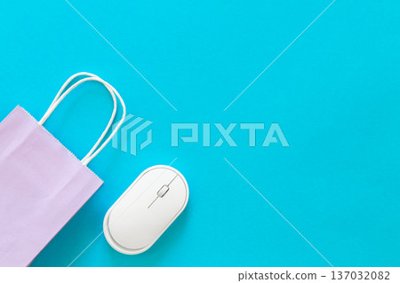 Computer mouse and paper bag on a blue background, top view. Computer mouse and paper bag on a blue background, top view. 137032082