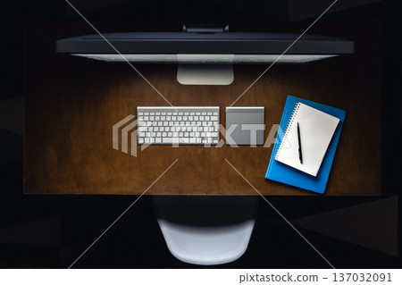 Computer, notepads and a cup of tea on the desktop at night, top view. 137032091
