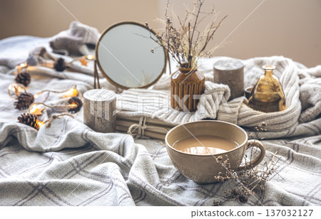 Cozy autumn composition with a cup of coffee and candles in bed. Cozy autumn composition with a cup of coffee and candles in bed. 137032127