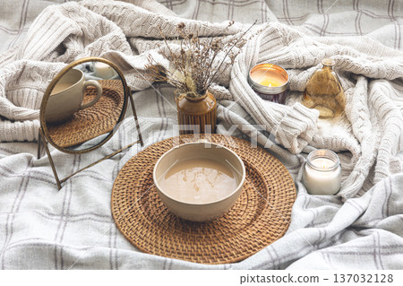 Cozy autumn composition with a cup of coffee and candles in bed. Cozy autumn composition with a cup of coffee and candles in bed. 137032128