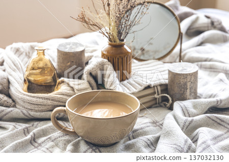 Cozy autumn composition with a cup of coffee and candles in bed. Cozy autumn composition with a cup of coffee and candles in bed. 137032130