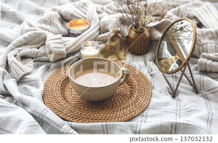Cozy autumn composition with a cup of coffee and candles in bed. Cozy autumn composition with a cup of coffee and candles in bed. 137032132