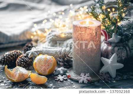 Cozy Christmas composition with a burning candle and decorative details. Cozy Christmas composition with a burning candle and decorative details. 137032168