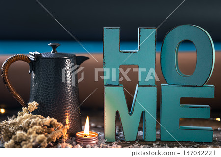 Cozy composition with decorative word home, teapot and candle. 137032221