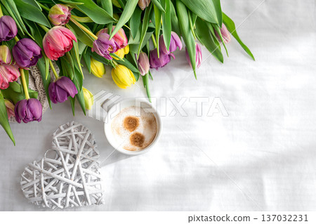 Cozy composition with flowers and coffee on a white background, top view. Cozy composition with flowers and coffee on a white background, top view. 137032231
