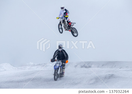 Motocross competing on snowy winter track 137032264
