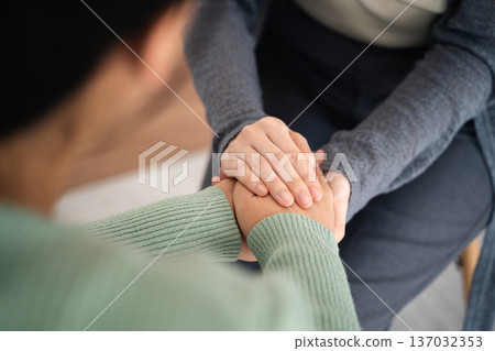 Psychologist or family holding hands to encourage patient with depression, mental health concept Psychologist or family holding hands to encourage patient with depression, mental health concept 137032353