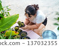 Young Asian woman holding a small cactus pot for planting and gardening. 137032355