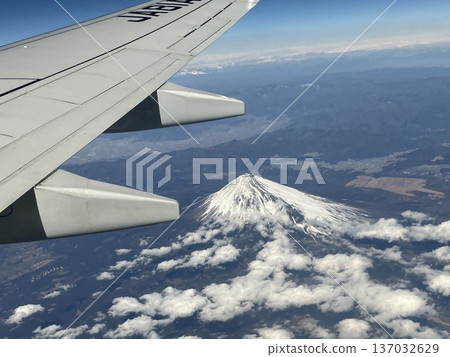 從飛機舷窗望出去，可以看到白雪皚皚的富士山和蔚藍的雲海。 137032629