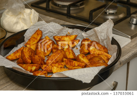 Raw Potato Wedges Ready for Oven on Parchment Paper Raw Potato Wedges Ready for Oven on Parchment Paper 137033061